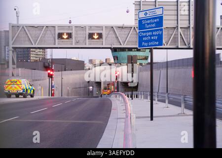 Silvertown, London. April 2025. Am nördlichen Eingang des Silvertown-Tunnels unter dem Schutz der Dunkelheit werden kurzfristige Räumungen und Sicherheitskontrollen durchgeführt. Während ein Polizeiauto Wache hält, führen die Wartungsteams die letzte „Säuberung“ der A1026-Zufahrtsstraßen nur wenige Stunden vor der Eröffnung des 7. April durch. Diese Mitternachtsszene geht der Einführung des ersten neuen Straßenübergangs in der SubThemse seit über 30 Jahren voraus. Der unberührte Zustand der Portalgebäude und Straßenmarkierungen ist hier vor Beginn des täglichen Verkehrs sichtbar. Quelle: Glosszoom/Alamy Live News Stockfoto