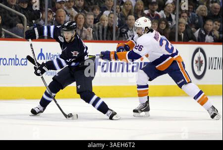 20. Dezember 2011: Winnipeg, Manitoba, Kanada – NHL 2011 – 20. Dezember; Winnipeg, MB, CAN; Winnipeg Jets Defenseman Tobias Enstrom (39), der den Pass erreicht, während Islander-Stürmer Matt Moulson (26) versucht, sich während der zweiten Periode im MTS Centre zu verteidigen. Obligatorischer Credit: Bobby Navasca – Southcreek Global Media (Bild: © Bobby Navasca/Southcreek/ZUMAPRESS.com) Stockfoto