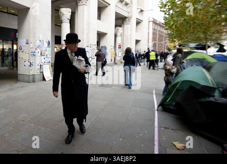 31. Oktober 2011 - London - Ein Mann in Bowler-Hut und -Anzug geht am 31. Oktober 2011 vor der St Pauls Cathedral in Central London über den Protest von Occupy London. Der Dekan der St. Paul's Cathedral in London wurde am Montag das zweite hochkarätige Geistliche Mitglied, das aufgrund der zunehmenden Kontroverse über antikapitalistische Proteste auf dem Kirchengelände zurücktrat. (Kreditbild: © Ki Price/ZUMAPRESS.com) Stockfoto