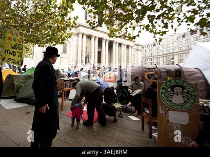31. Oktober 2011 - London - Ein Mann in Bowler-Hut und -Anzug geht am 31. Oktober 2011 vor der St Pauls Cathedral in Central London über den Protest von Occupy London. Der Dekan der St. Paul's Cathedral in London wurde am Montag das zweite hochkarätige Geistliche Mitglied, das aufgrund der zunehmenden Kontroverse über antikapitalistische Proteste auf dem Kirchengelände zurücktrat. (Kreditbild: © Ki Price/ZUMAPRESS.com) Stockfoto