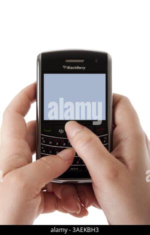 Frauenhände mit einem Blackberry Bold Smartphone-Computer mit leerem Bildschirm für Apps, optischem Trackpad und Tastatur, sim-Karte, isoliert, New York, USA, Stockfoto