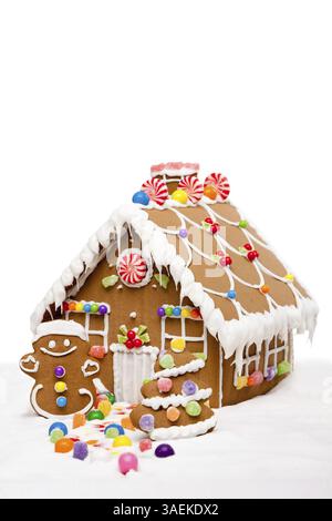 Lebkuchenhaus, Mann und Weihnachtsbaum bedeckt mit Schnee und bunten Süßigkeiten auf einer Winterlandschaft, isoliert, New York, USA, Nordamerika Stockfoto