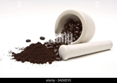 Ein Mörser mit frisch gerösteten Kaffeebohnen, vor dem ein Haufen Kaffeemühle auf weißem Hintergrund, New York, USA, Nordamerika Stockfoto