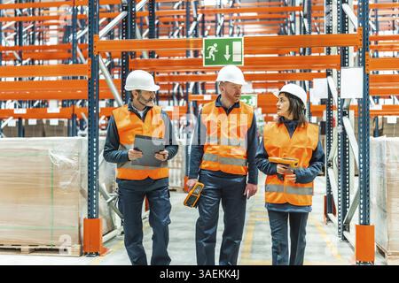 Lagerarbeiter laufen durch große Vertriebszentren und prüfen den Bestand mithilfe von Barcode-Scannern und Zwischenablage Stockfoto