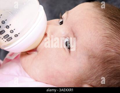 Niedliches Gesicht des Kaukasiers Hispanic Baby, Säugling trinkt Milch aus der Flasche, New York, USA, Nordamerika Stockfoto