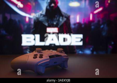 Eine Nahaufnahme eines weißen Gamepads mit der Marvel's Blade, die im Hintergrund auf dem Bildschirm zu sehen ist. Marvel's Blade ist ein bevorstehendes Action-Adventure-Spiel Stockfoto