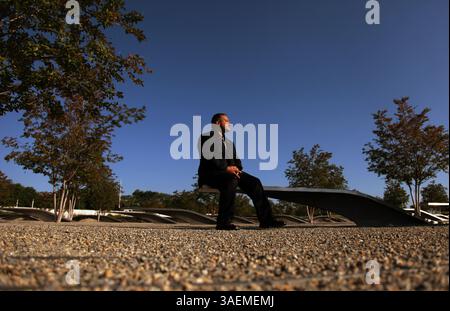 22. August 2011 - Arlington, VA, USA - Chris Braman sitzt auf einer der Bänke, die den Opfern der Terroranschläge vom 11. September gewidmet sind, die die Gedenkstätte 911 im Pentagon am 22. August 2011 bilden. „Ich komme von Zeit zu Zeit hierher, um mich zu erinnern“, sagt er. Am 11. September 2001 arbeitete Staff-Sgt. Christopher Braman im Pentagon als Koch, als der Plan zustande kam. Nachdem er dem Feuer entkommen war, rannte er mehrmals in das brennende Gebäude zurück und rettete am Ende eine Frau und brachte 63 Tote heraus. Er erhielt das Purple Heart für seine Verletzungen und die Soldatenmedaille für seine Tapferkeit. (Kreditbild Stockfoto