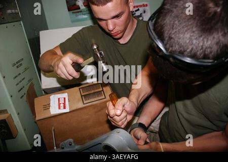 März 31, 2005; Al Asad, Irak; Corporal EMANUEL A. KRILE, ein gebürtiger Lancaster, Ohio, hilft Lance CPL BRANDON D. MITCHELL aus Lexington, S.C., bei einer 400-stündigen Inspektion eines Super CobraÕs Turms von AH-1W im März 31 eine verdrehte Schraube zu brechen. Krile und Mitchell sind Flugzeugentechniker der Marine Aviation Logistics Squadron 26 (verstärkt). Obligatorischer Ausweis: Foto von Sgt. Juan Vara/DOD/ZUMA Press. (©) Copyright 2005 by US DOD Photo Stockfoto