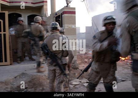 Dezember 2004; Fallujah, Irak; Marines mit Bravo Kompanie, Battalion Landing Team, 1. Bataillon, 3. Marine-Regiment, entladen Nahrung und Munition aus einem amphibischen Angriffsfahrzeug in der Stadt Falludschah. Die Lieferung der Vorräte wurde von Marines aus der Abteilung Training and Operations der Marine Expeditionary Unit Service Support Group 31 koordiniert. Stockfoto