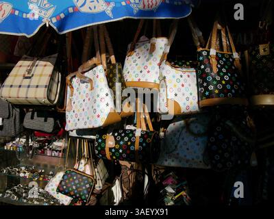 Dezember 2004; Venice Beach, CA, USA; gefälschte Louis Vuitton Taschen und Modeaccessoires – Produkte, die genau wie echte Designerwaren hergestellt wurden und einen Bruchteil der Kosten beim Verkauf auf dem Board Walk in Venedig Kalifornien verkauft haben. Touristen kaufen von Straßenhändlern gefälschte Designer-Handtaschen von Gucci, Prada und Louis Vuitton. Der Handel mit illegalen Fälschungen ist weltweit ein häufiges Problem. Stockfoto