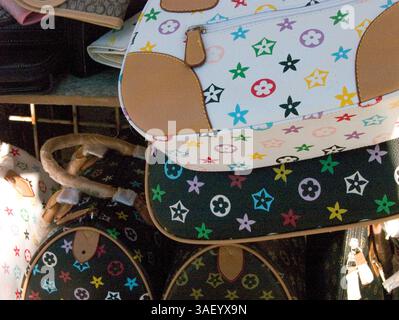 Dezember 2004; Venice Beach, CA, USA; gefälschte Louis Vuitton Taschen und Modeaccessoires – Produkte, die genau wie echte Designerwaren hergestellt wurden und einen Bruchteil der Kosten beim Verkauf auf dem Board Walk in Venedig Kalifornien verkauft haben. Touristen kaufen von Straßenhändlern gefälschte Designer-Handtaschen von Gucci, Prada und Louis Vuitton. Der Handel mit illegalen Fälschungen ist weltweit ein häufiges Problem. Stockfoto