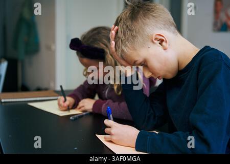 Junge und Mädchen, die Hausaufgaben zu Hause machen Stockfoto
