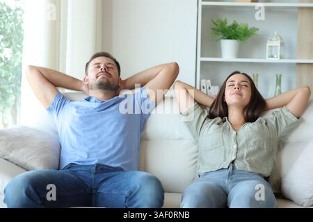 Glückliches Paar zu Hause, entspannend und entspannend auf einer Couch zu Hause Stockfoto