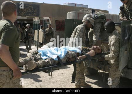 April 2005; Fallujah, Irak; Marine-Petty-Offizier 3. Klasse KRISTALL J. PURNELL, Kompanie C, 1. Bataillon, 6. Marine-RegimentÕs-Korpsman, hinten rechts, und andere Dozenten laden einen irakischen Soldaten auf ein Militärfahrzeug für den Transport in ein nahe gelegenes Krankenhaus. Der gebürtige Brooklyn, New York, und sein Team stabilisierten den Soldaten, nachdem er ohnmächtig wurde, während er als Einreisekontrollpunkt der Kompanie CÕs in die Stadt arbeitete. Obligatorische Angabe: Foto von CPL. Mike Escobar/DOD/ZUMA Press. (©) Copyright 2005 by US DOD Photo Stockfoto