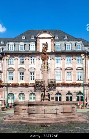 HEIDELBERG, DEUTSCHLAND - 7. JULI 2013: Menschen besuchen den Herkules Brunnen Heidelberg, Deutschland. Der Brunnen am zentralen Marktplatz wurde 1709 erbaut. Stockfoto