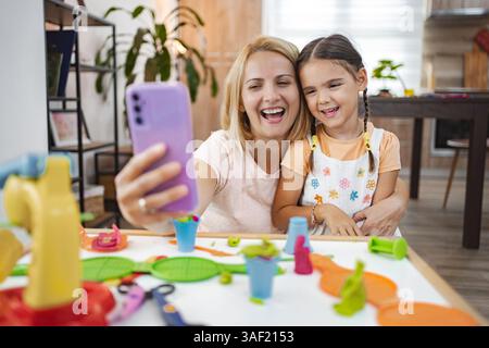 Mutter und Tochter genießen einen spielerischen Moment während sie ein Selfie machen Stockfoto