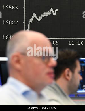 07. April 2025, Hessen, Frankfurt/Main: Während Börsenhändler vor ihren Monitoren auf dem Handelsplatz der Frankfurter Wertpapierbörse sitzen, zeigt die Anzeigetafel mit der Dax-Kurve einen Wert von weniger als 20.000 Punkten. Zu Beginn der neuen Handelswoche sank der deutsche Aktienindex (Dax) um rund zehn Prozent. Foto: Arne Dedert/dpa Stockfoto