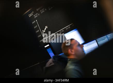 07. April 2025, Hessen, Frankfurt/Main: Während ein Börsenhändler vor seinen Monitoren auf dem Börsenboden der Frankfurter Wertpapierbörse sitzt, zeigt die Anzeigetafel mit der Dax-Kurve einen Wert von weniger als 20.000 Punkten. Zu Beginn der neuen Handelswoche sank der deutsche Aktienindex (Dax) um rund zehn Prozent. Foto: Arne Dedert/dpa Stockfoto
