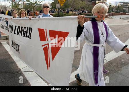 Januar 2005; Phoenix, AZ, USA; Rev. STEPHANIE BIKEL (R) von Desert Surprise United Church of Christ in Surprise, AZ, führt einen stillen marsch von Geistlichen durch die Innenstadt von Phoenix in die Hauptstadt des Bundesstaates Arizona, um gegen die Pläne der Legistlatures zu protestieren, eine Verfassungsänderung des Staates zu debattieren, die schwule Ehe verbieten würde. Der Klerus, Mitglieder von nicht mehr Silent, einer Organisation christlicher Geistlicher, die die Rechte schwuler Ehe unterstützt. Etwa 200 Menschen nahmen an dem marsch Teil. Stockfoto