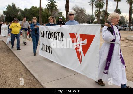 Januar 2005; Phoenix, AZ, USA; Rev. STEPHANIE BIKEL (R) von Desert Surprise United Church of Christ in Surprise, AZ, führt einen stillen marsch von Geistlichen durch die Innenstadt von Phoenix in die Hauptstadt des Bundesstaates Arizona, um gegen die Pläne der Legistlatures zu protestieren, eine Verfassungsänderung des Staates zu debattieren, die schwule Ehe verbieten würde. Der Klerus, Mitglieder von nicht mehr Silent, einer Organisation christlicher Geistlicher, die die Rechte schwuler Ehe unterstützt. Etwa 200 Menschen nahmen an dem marsch Teil. Stockfoto