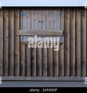 Scheunentür aus Holz mit Metallscharnieren und Verriegelung Stockfoto
