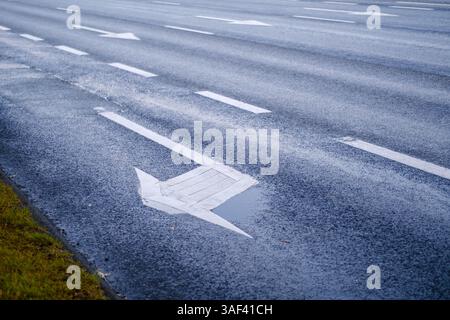 Eine Straße mit weißen Pfeilen drauf Stockfoto