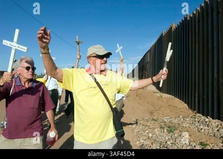 April 2005; Naco, AZ, USA; die Teilnehmer spazieren entlang der Grenzmauer zwischen den USA und Mexiko während einer interreligiösen Prozession und einem Gebetsgottesdienst in Naco, AZ. Die Teilnehmer kamen aus Kirchen in Bisbee, Naco, Tucson und Douglas, Arizona und Naco, Mexiko, zusammen. um gegen die Aktionen der Freiwilligen des Minuteman-Projekts zu protestieren. Etwa 250 Menschen aus Arizona und Mexiko nahmen an der Veranstaltung Teil. Das Minuteman Project ist ein freiwilliges Projekt, um illegale Einwanderer davon abzuhalten, ohne Dokumente in die USA einzureisen. Die Minuteman-Freiwilligen rufen die Grenzpolizei an, wenn sie Einwanderer ohne Papiere sehen Stockfoto