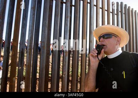 April 2005; Naco, AZ, USA; ein Minister führt ein Gebet während eines marsches entlang der Grenzmauer zwischen den USA und Mexiko während einer interreligiösen Prozession und einem Gebetsgottesdienst in Naco, AZ. Die Teilnehmer kamen aus Kirchen in Bisbee, Naco, Tucson und Douglas, Arizona und Naco, Mexiko, zusammen. um gegen die Aktionen der Freiwilligen des Minuteman-Projekts zu protestieren. Etwa 250 Menschen aus Arizona und Mexiko nahmen an der Veranstaltung Teil. Das Minuteman Project ist ein freiwilliges Projekt, um illegale Einwanderer davon abzuhalten, ohne Dokumente in die USA einzureisen. Die Minuteman-Freiwilligen rufen die Grenzpolizei an, wenn sie Undokume sehen Stockfoto