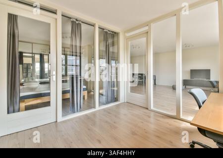 Elegant gestaltete, moderne Inneneinrichtung mit Glastrennwänden, Holzfußboden und minimalistischer Einrichtung, perfekt für moderne Wohnräume oder Büros. Stockfoto