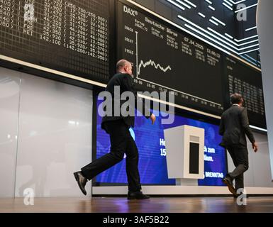07. April 2025, Hessen, Frankfurt/Main: Zwei Männer gehen an der Schautafel vorbei, die die Dax-Kurve in der Handelshalle der Frankfurter Börse zeigt. Zu Beginn der neuen Handelswoche sank der deutsche Aktienindex (Dax) um rund zehn Prozent. Foto: Arne Dedert/dpa Stockfoto