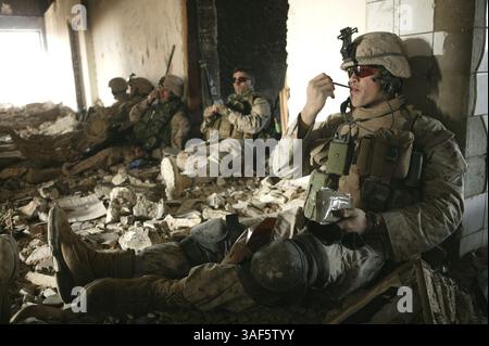 28. Februar 2005; Haqlaniyah, Irak; CPL CARLOS A. FELIX JR., ein Truppenführer beim 1st Platoon, Charley Company, 1/7, RCT-7, genießt einige Momente der Ausfallzeit zusammen mit dem Rest seiner Truppe, während sie sich in Deckung in einem ausgebrannten Hotel in Haqlaniyah machen. In diesem Gebäude nahmen die Marines am 23. Februar Maschinengewehrfeuer von der Insel auf der anderen Seite des Flusses. Stockfoto