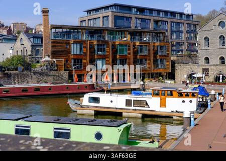 Ein sonniger Tag im Bristol Harbour, England, bietet eine lebhafte Szene mit farbenfrohen Hausbooten, die am Ufer angedockt sind. Stockfoto