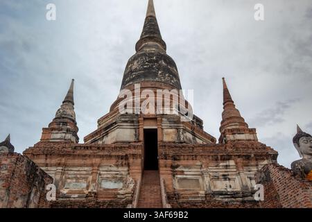 Rote Ziegelsteine und Steintempelruine Gebäudekomplex und goldene buddha-Statue des historischen Parks Wat Yai Chai Mongkhon in Ayutthaya in Thailand Stockfoto