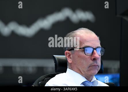 07. April 2025, Hessen, Frankfurt/Main: Während ein Händler auf der Börse der Frankfurter Wertpapierbörse seine Monitore beobachtet, ist im Hintergrund die Anzeigetafel mit der Dax-Kurve zu sehen. Zu Beginn der neuen Handelswoche sank der deutsche Aktienindex (Dax) um rund zehn Prozent. Foto: Arne Dedert/dpa Stockfoto