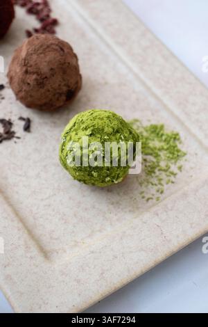 Matcha und Kakaotrüffel auf einer hellen Farbtafel Stockfoto