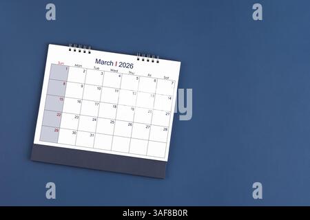 März 2026 monatlicher Tischkalender auf blauem Hintergrund, Position mit Kopierraum. Flache Lagen. Stockfoto
