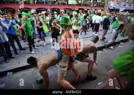 März 2012: Savannah, Georgia, USA S - drei Menschen tanzen auf der Straße vor einer Menschenmenge auf der River Street im historischen Stadtteil nach der Savannah St. Patrick's Day-Parade. Savannah rühmt sich der Feier als eine der größten Menschenmassen und längsten Paraden des Landes. (Bild: © Stephen Morton/ZUMAPRESS.com) Stockfoto