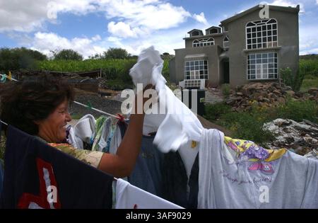 Benigna de la Cruz, 45, zieht vor einem fast kompletten Haus in Remedios Wäsche von der Schlange. Ihr Schwiegersohn, ein 28-jähriger College-Absolvent und Röntgentechniker, verbrachte mehrere Jahre in der Gegend von Clearwater und arbeitete als Gärtner und Klempner, um Geld nach Hause zu schicken, um das Haus zu bauen. Wenn er fertig ist, wird er wieder bei seiner Familie leben. (Bild: St. Petersburg Times/ZUMAPRESS.com) Stockfoto