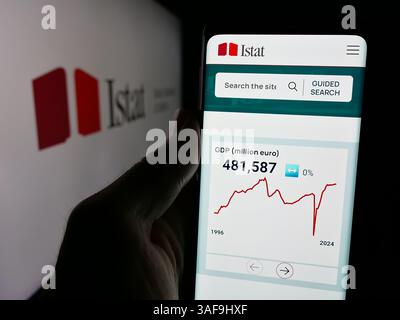 Stuttgart, Deutschland - 21.11.2024: Person, die ein Handy hält, mit Webseite des italienischen Istituto Nazionale di Statistica (Istat) auf dem Bildschirm mit Logo. Stockfoto