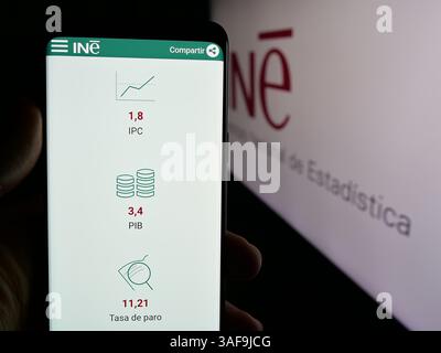 Stuttgart, Deutschland - 21.11.2024: Person, die ein Handy hält, mit Webseite des spanischen Instituto Nacional de Estadistica (INE) auf dem Bildschirm mit Logo. Stockfoto