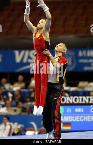 August 2003; Anaheim, Kalifornien, USA; FABIAN HAMBUECHEN aus Deutschland wird vom 16. bis 24. August beim Mannschaftswettbewerb der Männer bei den Turn-Weltmeisterschaften 2003 vom Trainer in die Ringe gehoben. Hambuechen ist youngest.competitor mit 15 Jahren. (Bild: Tom Theobald/ZUMAPRESS.com) Stockfoto