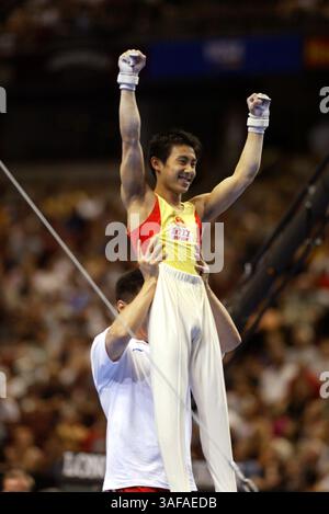 August 2003; Anaheim, Kalifornien, USA; HAIBIN TENG AUS China wird vom Trainer nach der horizontalen Bar des letzten Events hochgehoben. steigen Sie aus, um den Mannschaftswettbewerb der Männer beim World Artistic Gymnastics 2003 vom 16. bis 24. August zu gewinnen. (Bild: Tom Theobald/ZUMAPRESS.com) Stockfoto