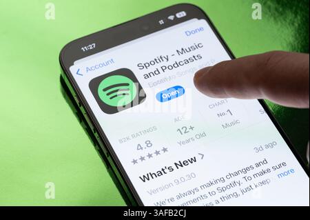 New York, USA – 30. März 2025: Spotify App wird auf dem Smartphone-Bildschirm geöffnet Stockfoto