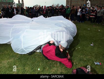 20. April 2012 - Ottawa, Ontario, Kanada - Ein Mann mit einer Bong, der in einen großen Kokon einsteigt und sich den anderen Pottwauchern während eines marsches anschließt, der am 20. April 2012 die Entkriminalisierung von Marihuana oder die 4:20-Bewegung auf dem Parliament Hill in Ottawa forderte (Credit Image: © Kamal Sellehuddin/ZUMAPRESS.com) Stockfoto