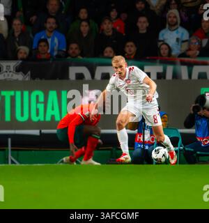 Lissabon, Portugal. März 2025. UEFA Nations League: Portugal gegen Dänemark. Gustav Isaksen (8) aus Denmar wurde von Nuno Mendes überholt Stockfoto