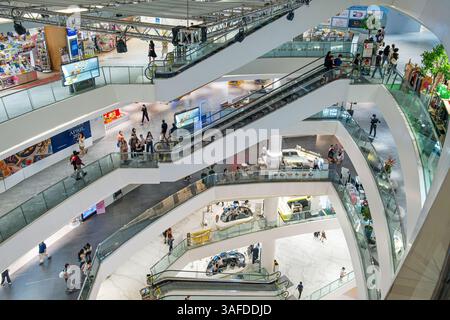 Bangkok, Thailand - 2. Februar 2025: Innenraum des Iconsiam Einkaufszentrums mit mehreren Rolltreppen und Personen, die sich über verschiedene Ebenen bewegen. Modern Stockfoto