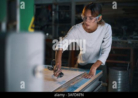 Schilder Für Weibliche Mitarbeiter In Der Werkstatt Stockfoto