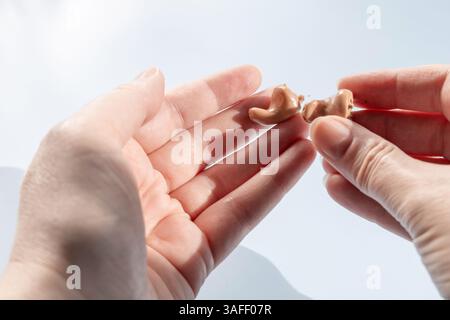 Arzt hält modernes Hörgerät. Hörlösungen. Stockfoto