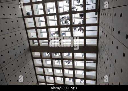 Blick von unten auf Menschen, die auf dem Glasboden des Akropolis-Museums laufen, entworfen von Bernard Tschumi in Athen, Griechenland. Stockfoto