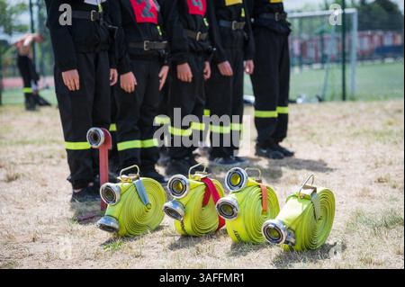 Feuerwehrschläuche am Boden und in den Feuerwehren im Hintergrund Stockfoto